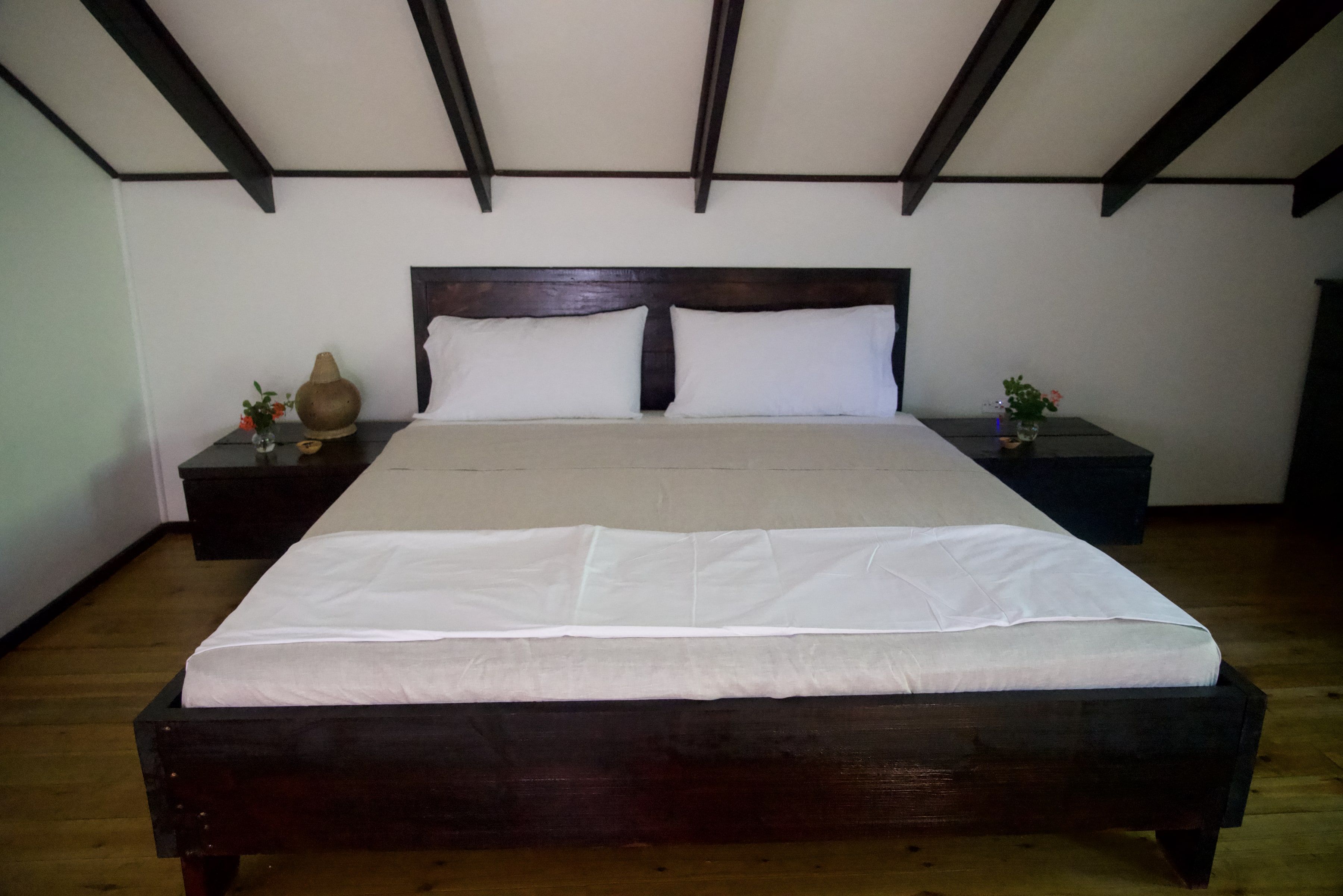 The king bed in the bedroom, under the roof beams