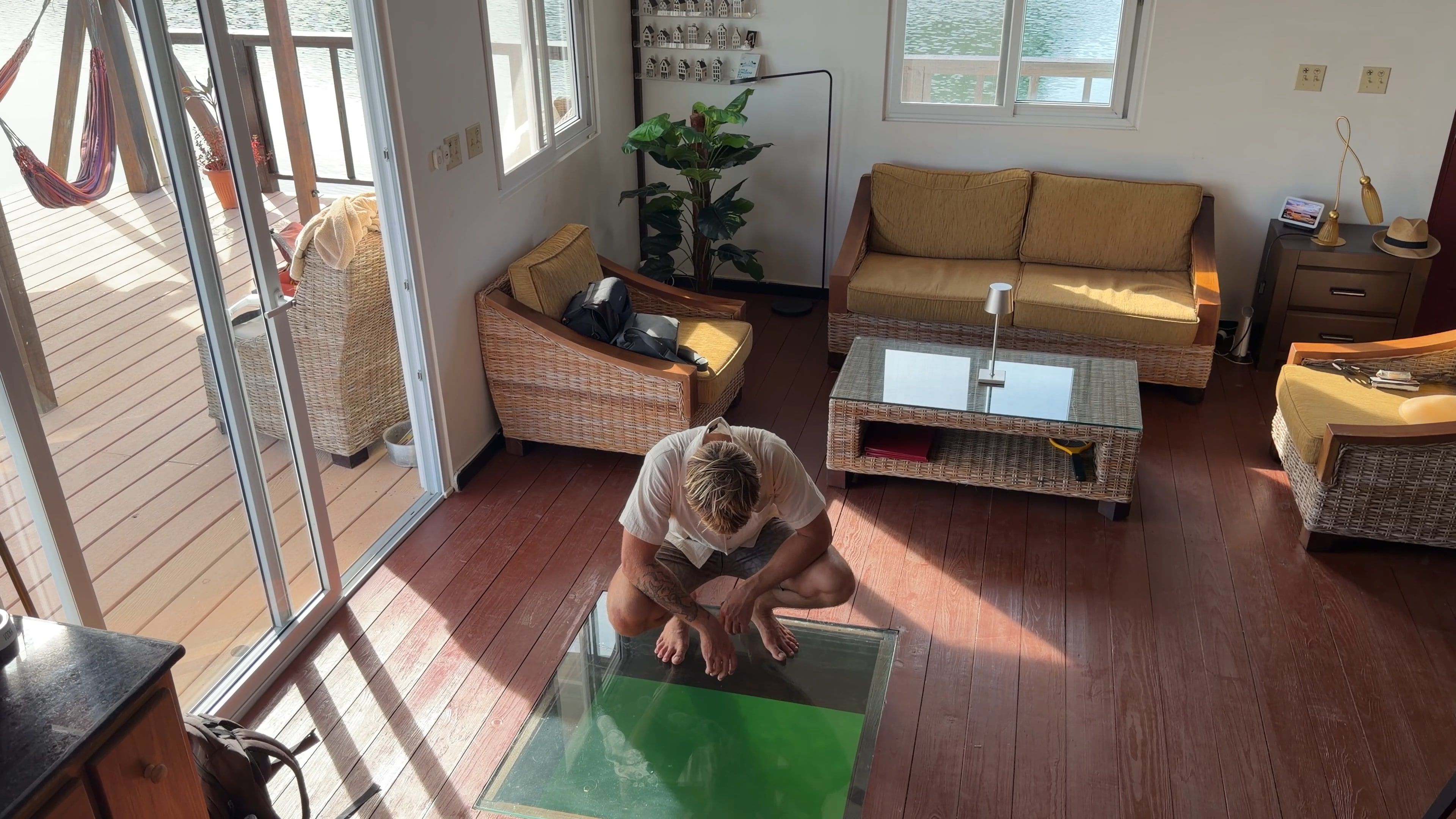 The living room from above: someone looks at the water through the glass floor