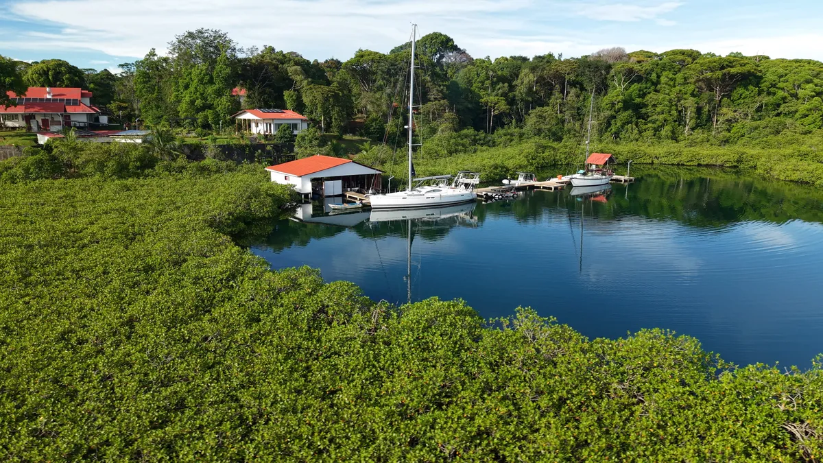 The resort's dock on the lagoon, with two sailboats tied up, among the mangroves