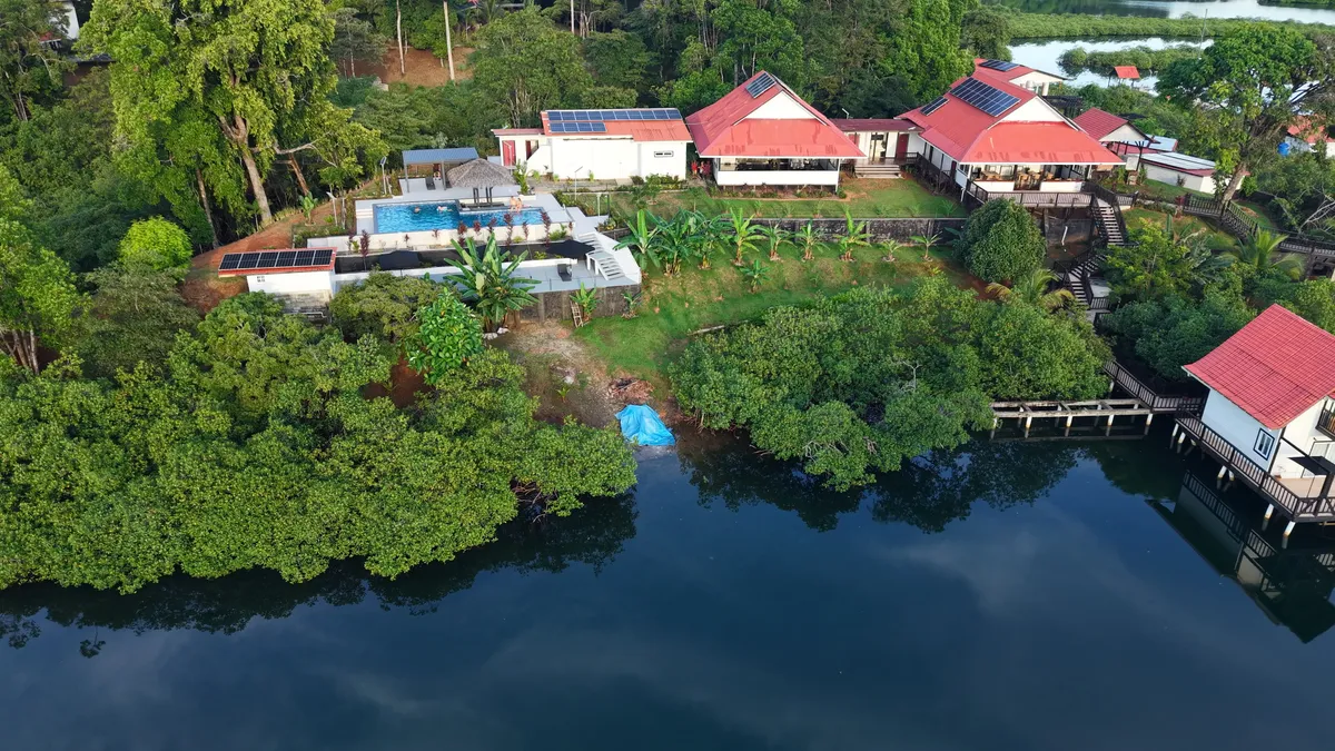 Six Pillars Resort from the air: the pool, the restaurant and a bungalow over the lagoon, in the jungle