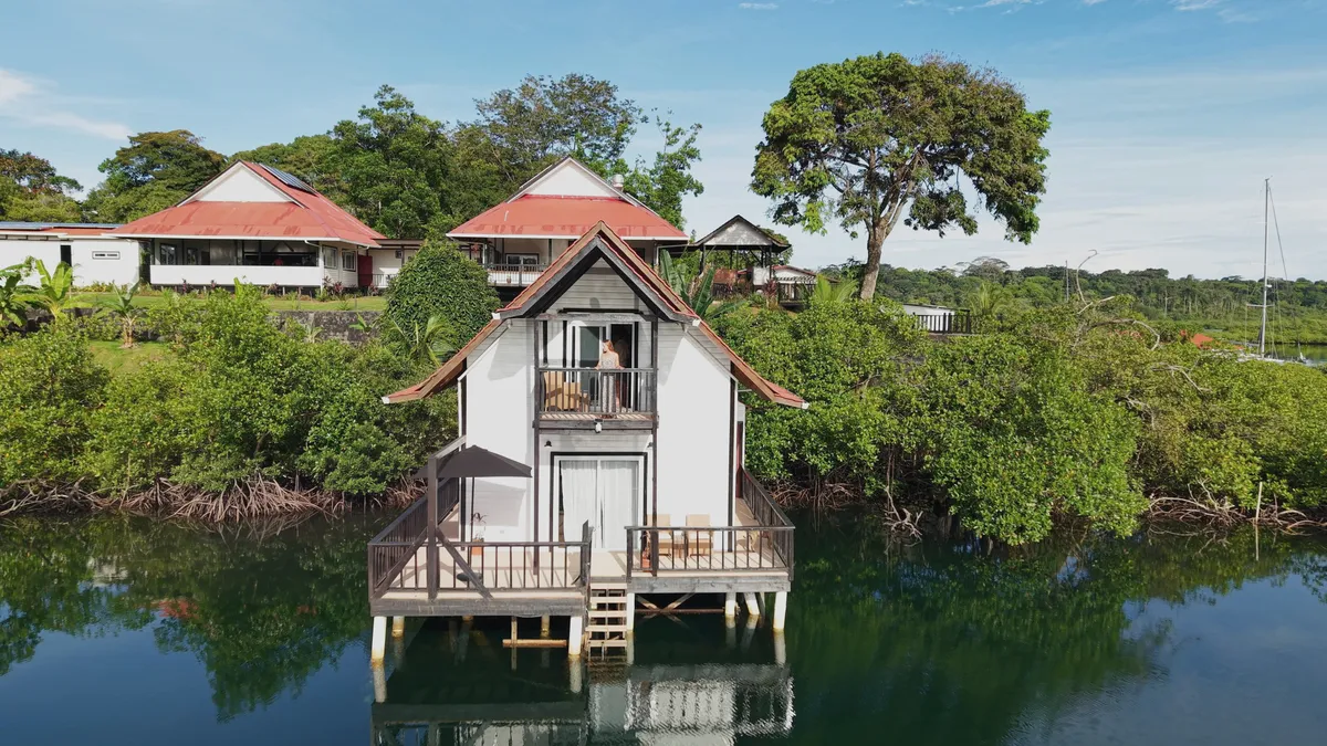 Casa del Mar from the front, over the lagoon, with the resort's red roofs behind it
