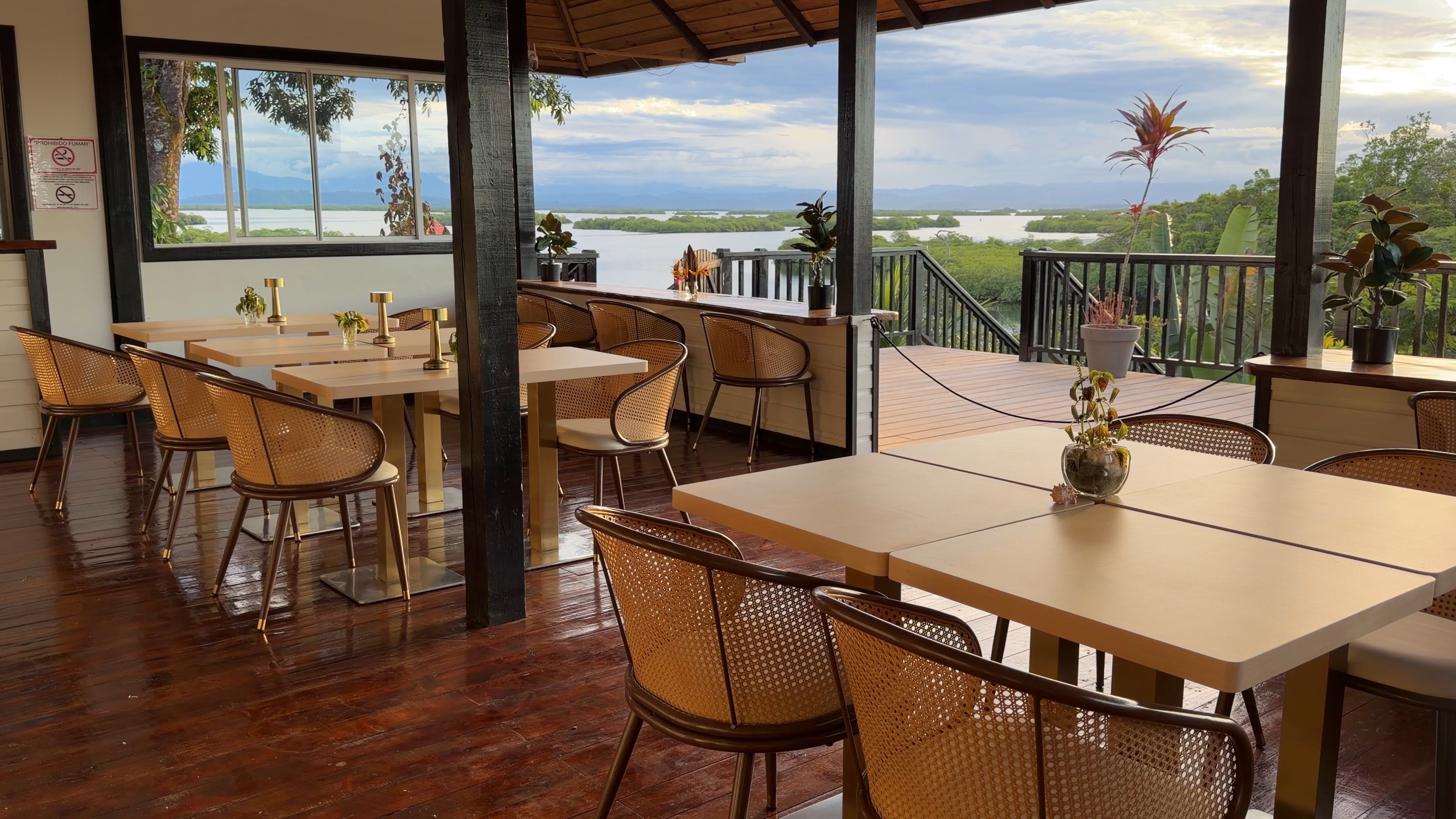 The open-air restaurant: wooden tables and cane chairs, with the lagoon and the islands beyond