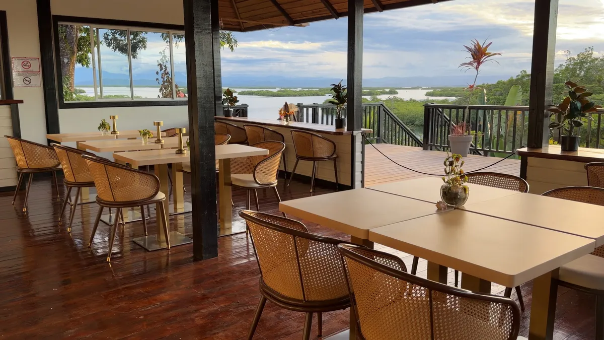 The open-air restaurant: wooden tables and cane chairs, with the lagoon and the islands beyond