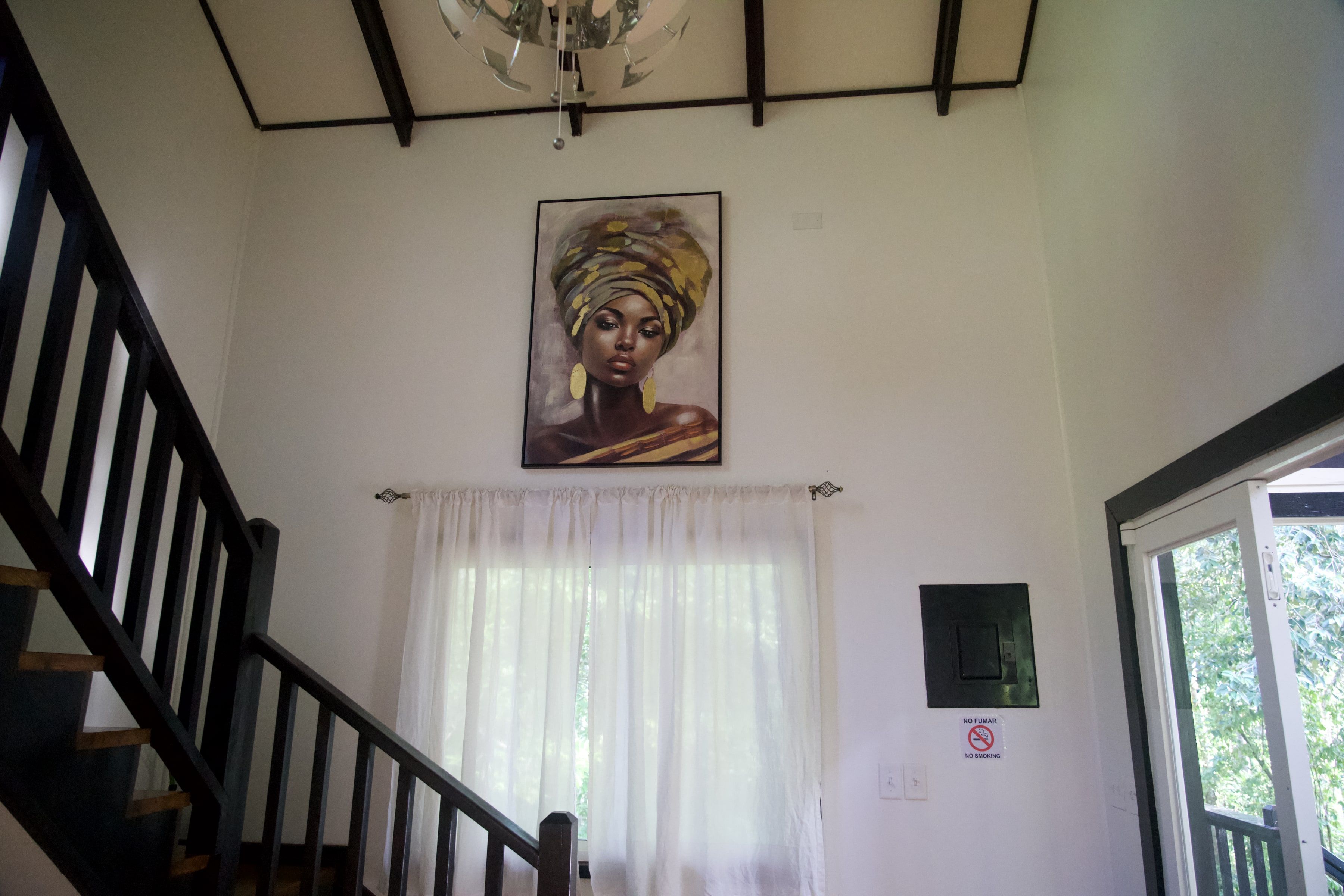 The double-height interior, with the stairs to the bedroom and a painting above the window