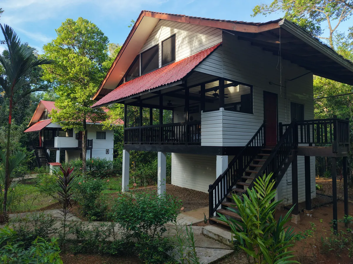 A Jungle Lodge up close: the screened living room, the entrance stairs and the other lodge behind